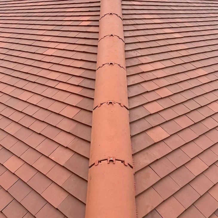 Red plain tiles with a new mechanically fixed ridge
