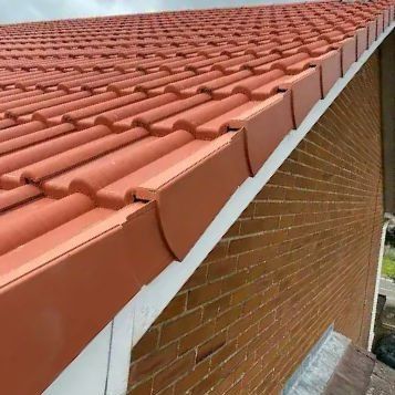 Red interlocking tiles with a dry verge system on a gable end
