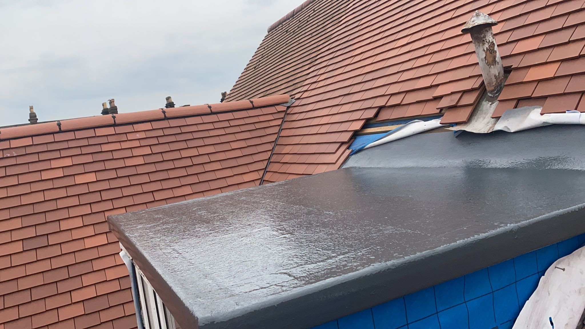 GRP flat roof on a dormer beside a red tiled roof