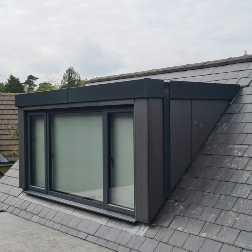 Modern dormer clad in dark grey panels on a slate roof
