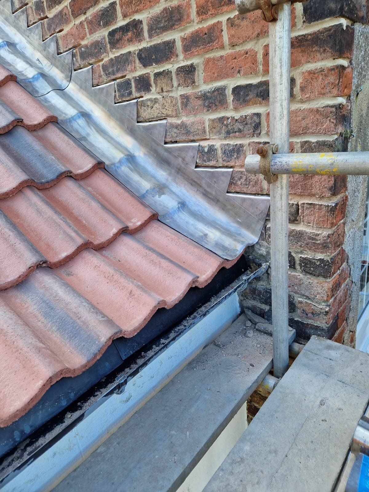 Lead abutment flashing where a tiled roof meets a brick wall