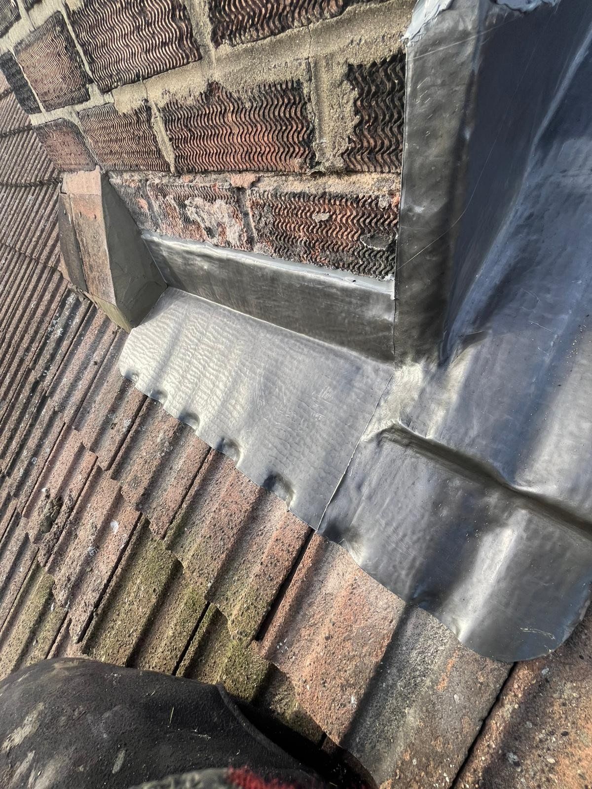 Lead flashing around a chimney on a tiled roof