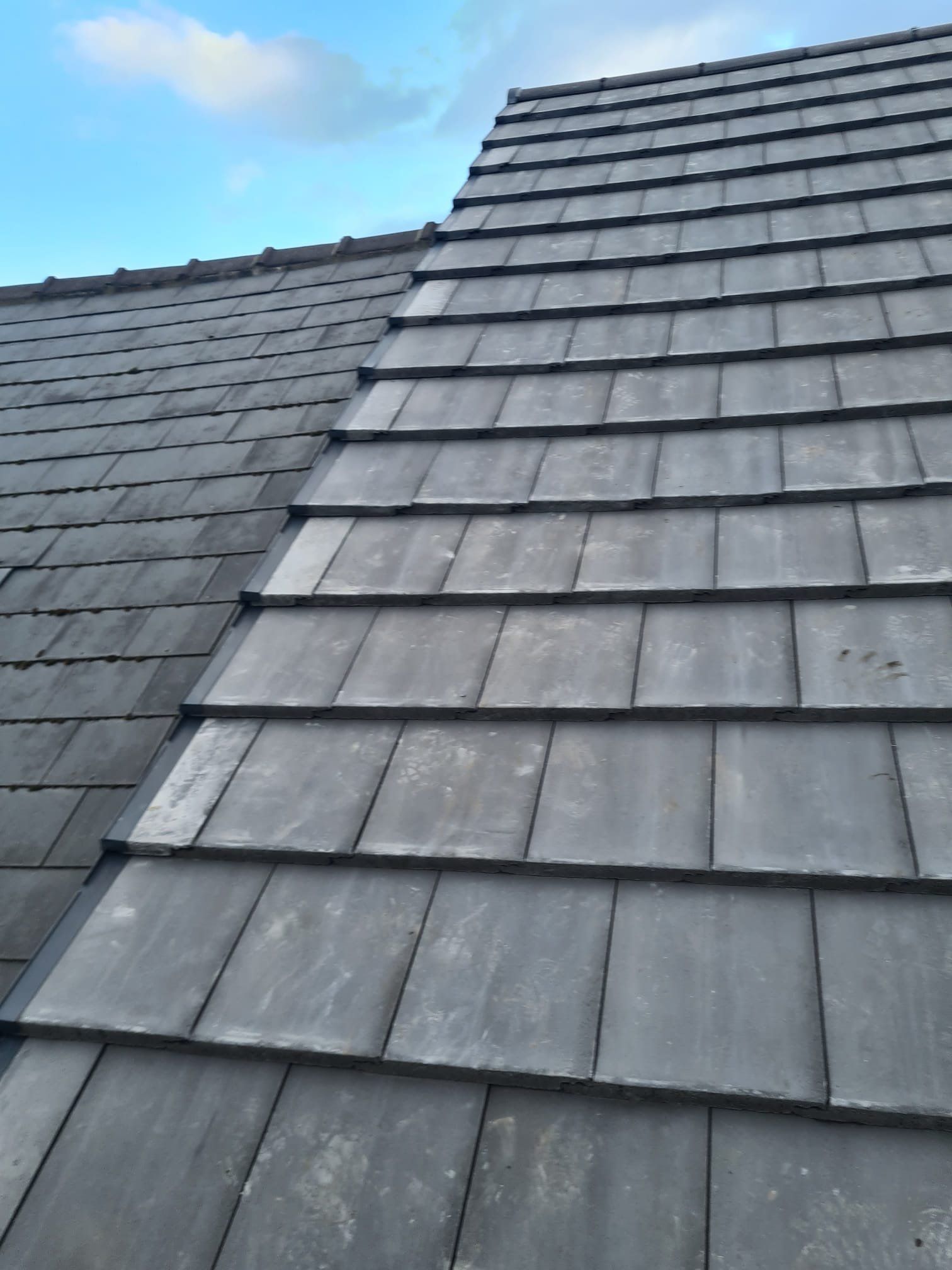 Newly laid grey slate-effect tiles on a pitched roof