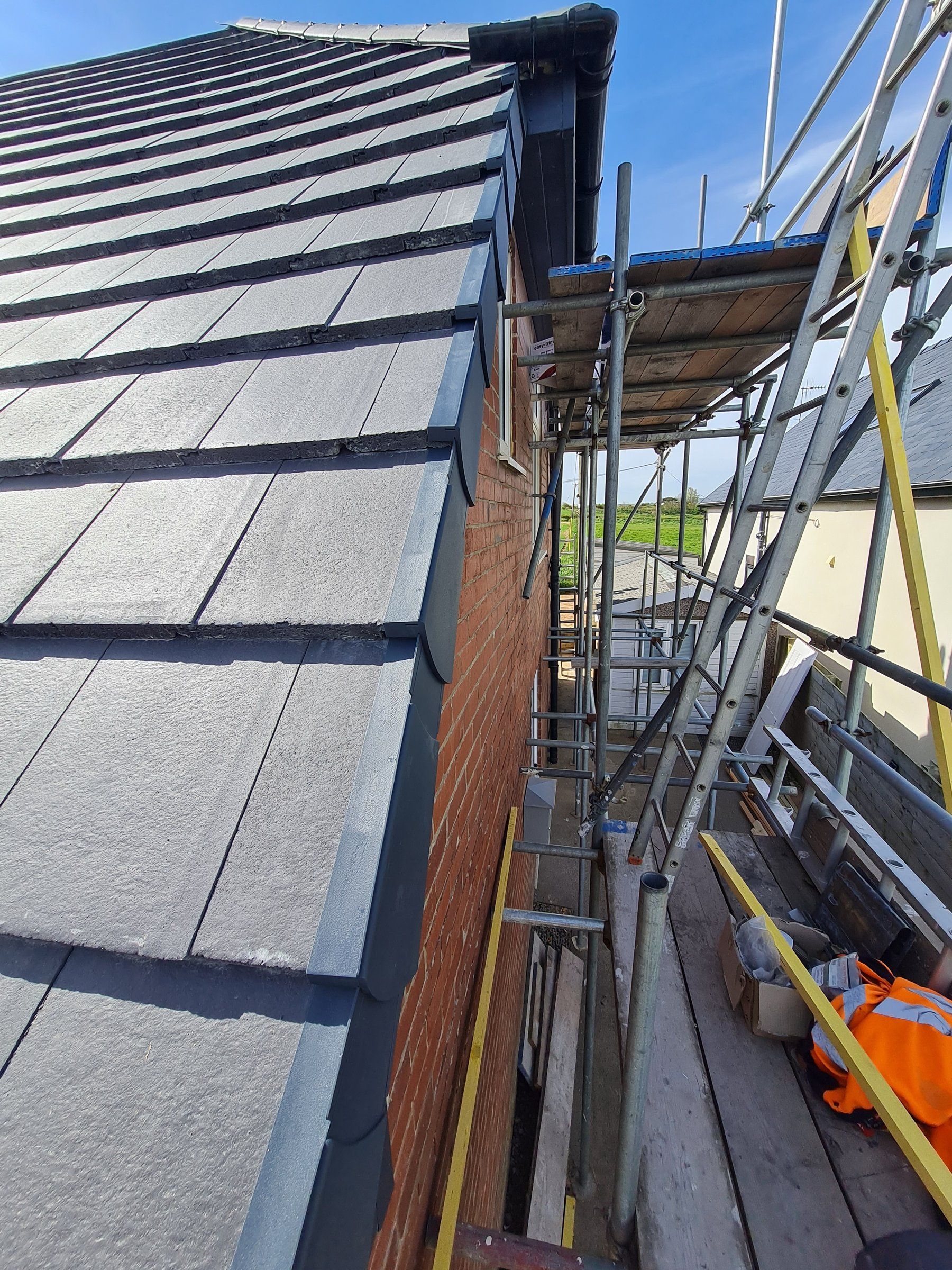 Re-roofed slate-effect tiles with scaffolding along the gable