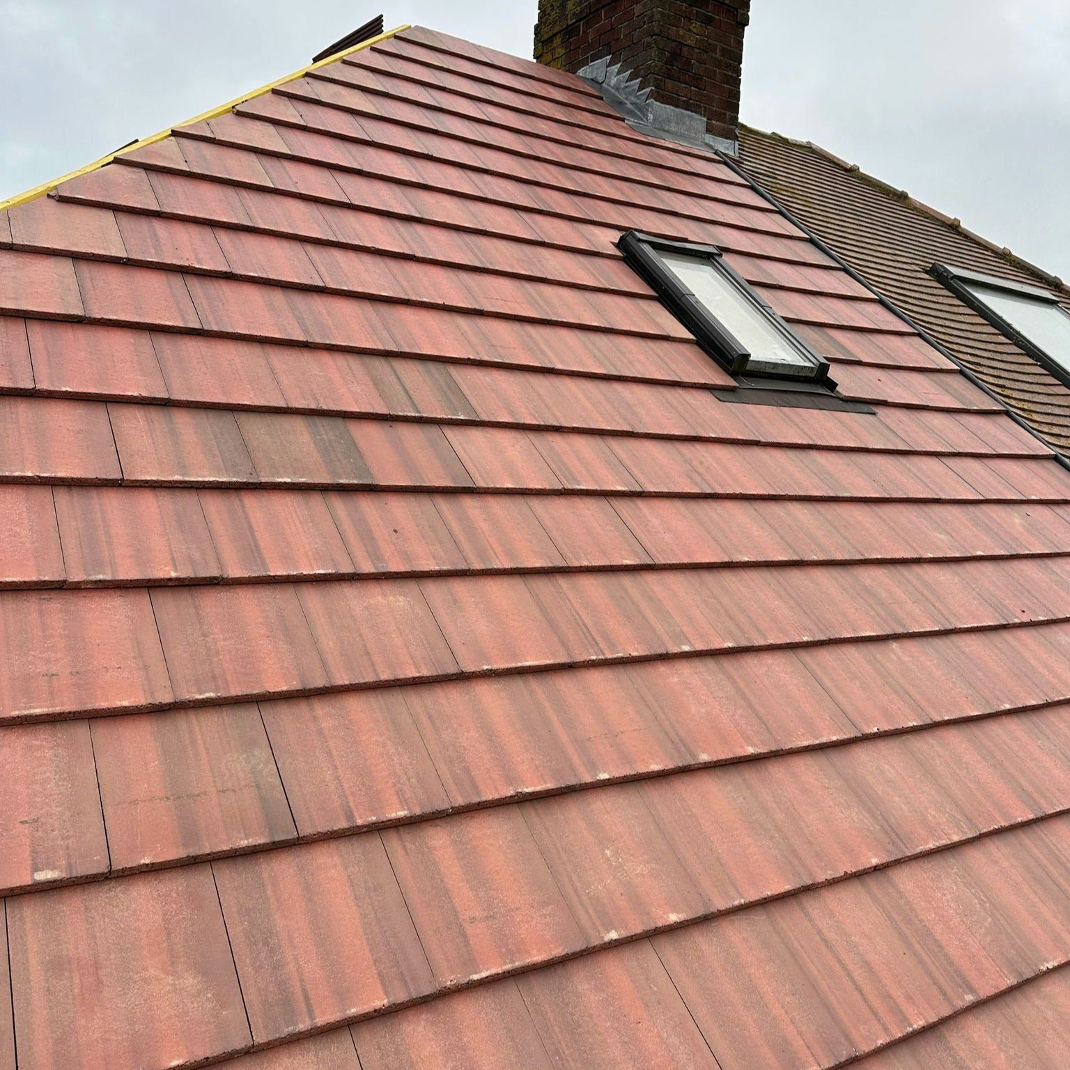 Finished brindle plain-tile roof with a roof window