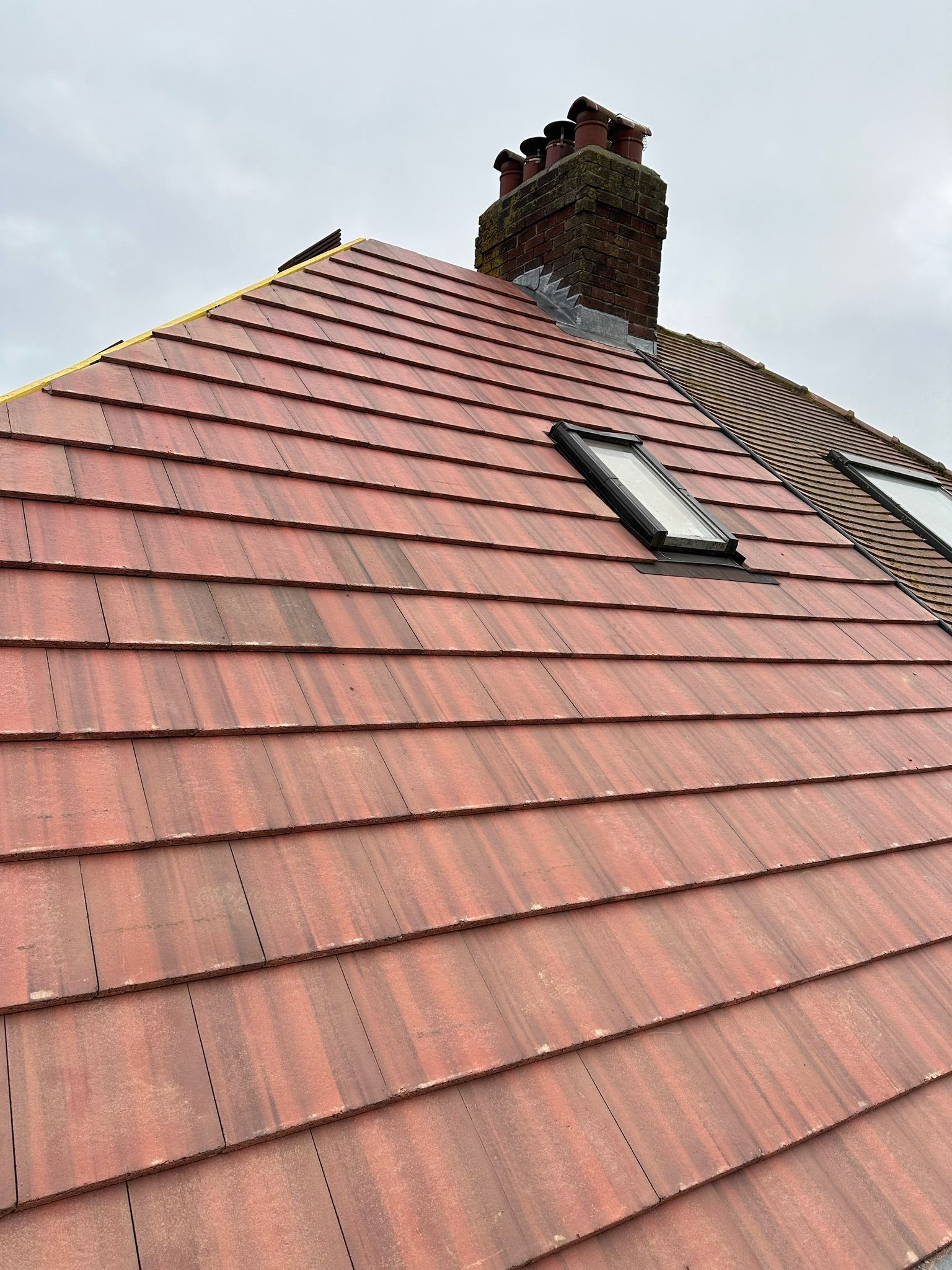Red plain-tile roof with a roof window and chimney