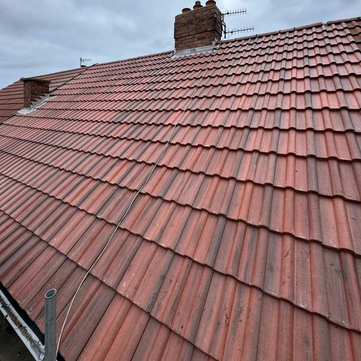 Red interlocking tiled roof with a chimney stack