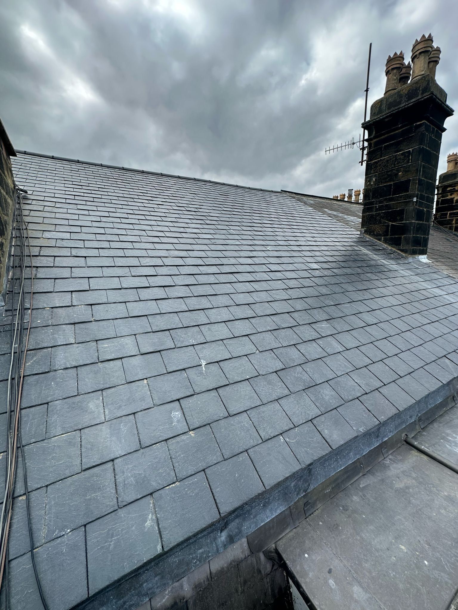 Newly slated roof with a brick chimney stack