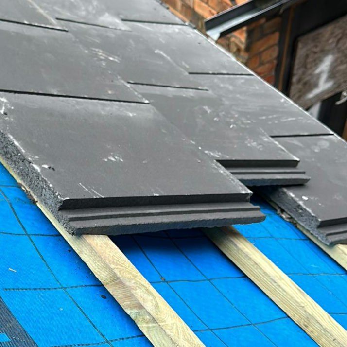 New slates laid out on battens over blue membrane